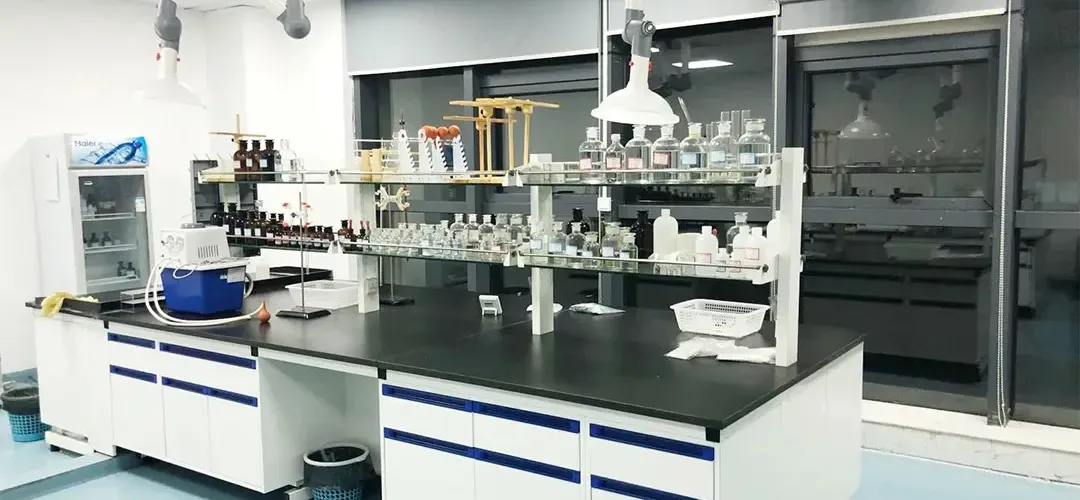 Modern quality control laboratory with analytical instruments including gas chromatograph and HPLC systems for chemical analysis