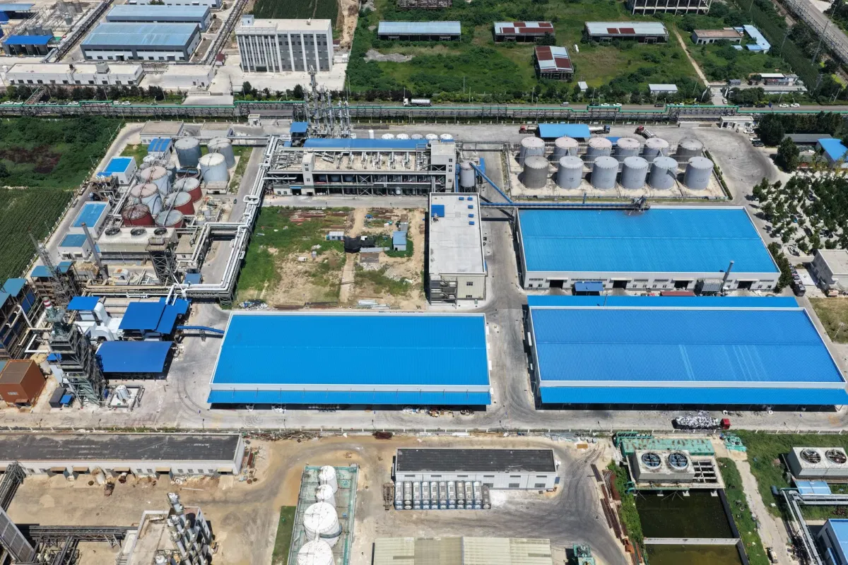 Blue-roof warehouses at Wansheng plasticizer factory China storing recycled PET feedstock for DOTP production
