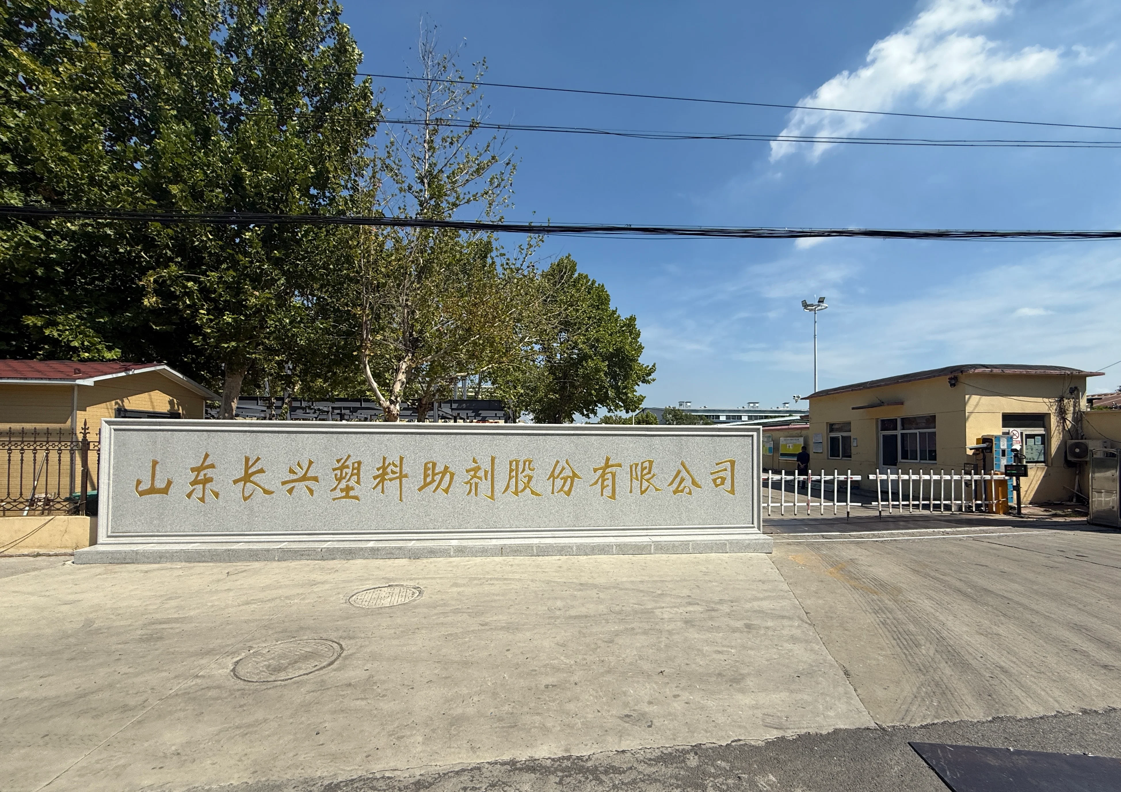 Shandong Changxing Plastic Additives factory entrance — company name engraved on stone monument at Jining Canal Economic Development Zone headquarters